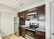 Thumbnail 1 of 60 - A kitchen with brown cabinets and stainless steel appliances. at Venue at 109 Apartments, Tennessee, 37090