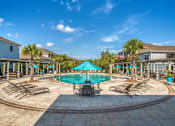 Thumbnail 34 of 41 - A large swimming pool surrounded by lounge chairs and umbrellas.