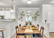 Thumbnail 8 of 39 - A dining room with a wooden table set for a meal.