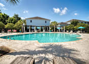 Thumbnail 35 of 41 - A large swimming pool in front of a building with a white fence around it.