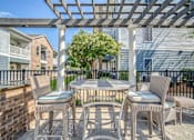 Thumbnail 39 of 41 - A patio with a table and chairs under a pergola.
