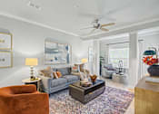 Thumbnail 8 of 48 - A living room with a grey couch, a brown chair, a coffee table, and a ceiling fan.