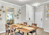 Thumbnail 7 of 39 - A dining room with a wooden table set for a meal.