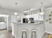 Thumbnail 10 of 39 - A kitchen with a bar area and two stools.