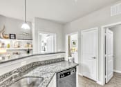 Thumbnail 12 of 39 - A modern kitchen with a granite countertop and stainless steel appliances.