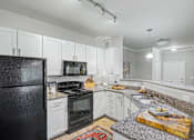 Thumbnail 10 of 48 - A kitchen with black appliances and white cabinets.