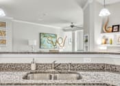 Thumbnail 13 of 39 - A modern kitchen with a granite countertop and a sink.