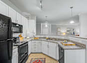 Thumbnail 13 of 48 - A kitchen with black appliances and white cabinets.