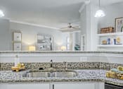 Thumbnail 17 of 48 - A kitchen with a granite countertop and a double sink.