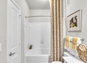 Thumbnail 21 of 39 - A bathroom with a white tub and a white door.