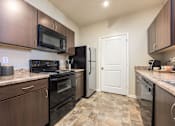 Thumbnail 6 of 40 - A kitchen with a black refrigerator and stove.