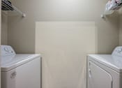Thumbnail 12 of 40 - Two white front loading washing machines in a small laundry room.