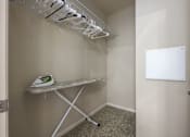 Thumbnail 10 of 40 - A white ironing board with clothes hangers on the wall.