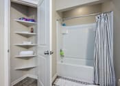 Thumbnail 7 of 40 - A white bathroom with a white tub and a white shower curtain.