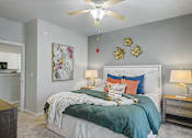 Thumbnail 19 of 48 - A bedroom with a bed, nightstands, and a ceiling fan.