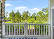 Thumbnail 23 of 48 - A view from a porch looking out to a yard and trees.