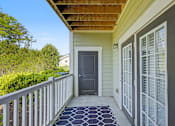 Thumbnail 25 of 48 - A small house with a grey door and a grey mat on the porch.