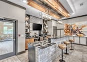 Thumbnail 27 of 39 - A modern kitchen with a stone counter and a bar area.