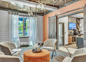 Thumbnail 25 of 39 - A living room with a large window and a dining area in the background.