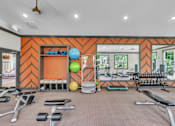 Thumbnail 35 of 39 - A gym with orange walls and a variety of equipment.