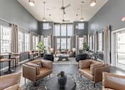Thumbnail 31 of 38 - A large, modern living room with brown leather furniture and a glass door leading to a balcony at Prosper Madison Oaks, Madison, AL