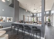 Thumbnail 34 of 38 - A modern kitchen with a bar area and grey chairs at Prosper Madison Oaks, Madison, AL