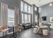 Thumbnail 36 of 38 - A modern living room with a grey theme and a large window at Prosper Madison Oaks, Madison, AL
