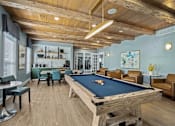 Thumbnail 23 of 41 - A pool table is in the middle of a room with a wooden floor and ceiling.