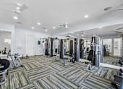 Thumbnail 29 of 41 - A gym with a variety of equipment including treadmills, weights, and exercise machines.