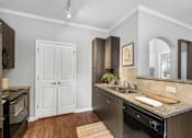 Thumbnail 9 of 41 - A kitchen with a black oven and a white door.