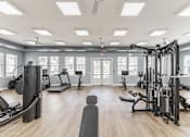 Thumbnail 26 of 38 - A spacious gym with a variety of equipment and a large mirror on the wall at Prosper Madison Oaks, Madison, AL