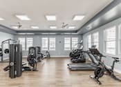 Thumbnail 27 of 38 - A spacious gym with a variety of equipment including treadmills, stationary bikes, and weight machines at Prosper Madison Oaks, Madison, AL