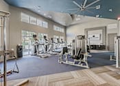 Thumbnail 34 of 48 - A gym with a variety of equipment including treadmills, weights, and exercise machines.