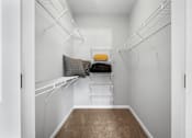 Thumbnail 17 of 41 - A walk-in closet with white shelves and a brown carpet.