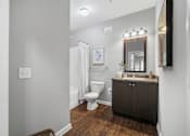 Thumbnail 15 of 41 - A bathroom with a toilet, sink, and mirror.