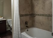 Thumbnail 16 of 30 - a bathroom with a tub and a shower and a toilet