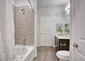 Thumbnail 8 of 30 - A bathroom with a toilet, sink, and shower.