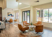 Thumbnail 27 of 30 - a living room with chairs and a table and sliding glass doors