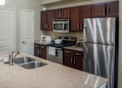 Thumbnail 19 of 30 - a kitchen with stainless steel appliances and granite counter tops