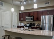 Thumbnail 20 of 30 - a kitchen with a granite counter top and stainless steel appliances