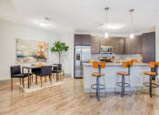 Thumbnail 9 of 19 - a kitchen with a bar and a dining area with chairs at The Mark, San Antonio, 78230