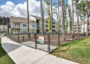 Thumbnail 2 of 14 - a fenced in dog park in front of an apartment building at Sterling Creek, Richmond Hill, GA
