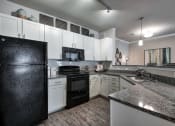 Thumbnail 9 of 14 - a kitchen with granite counter tops and black appliances at Sterling Creek, Georgia