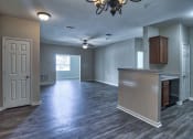 Thumbnail 6 of 10 - an empty living room with a kitchen and a ceiling fan at Mill Creek Run, Macon, GA