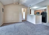 Thumbnail 9 of 10 - an empty living room with a kitchen and a ceiling fan at Mill Creek Run, Georgia