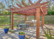 Thumbnail 7 of 20 - a patio with a table and chairs under a wooden pergola at Spring Creek Apartments, Crestview, FL 32536