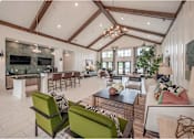Thumbnail 28 of 74 - A modern living room with a stone fireplace and a large green sofa at Waterleaf at Neely Ferry Apartments, Simpsonville, South Carolina