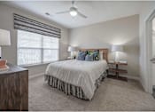 Thumbnail 30 of 74 - A bedroom with a bed, two lamps, and a window with blinds at Waterleaf at Neely Ferry Apartments, Simpsonville, 29680