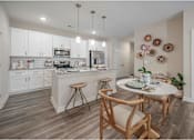 Thumbnail 31 of 74 - A kitchen with a table and chairs in the middle at Waterleaf at Neely Ferry Apartments, Simpsonville, South Carolina