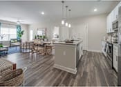 Thumbnail 32 of 74 - A modern kitchen with a wooden floor and stainless steel appliances at Waterleaf at Neely Ferry Apartments, Simpsonville, SC